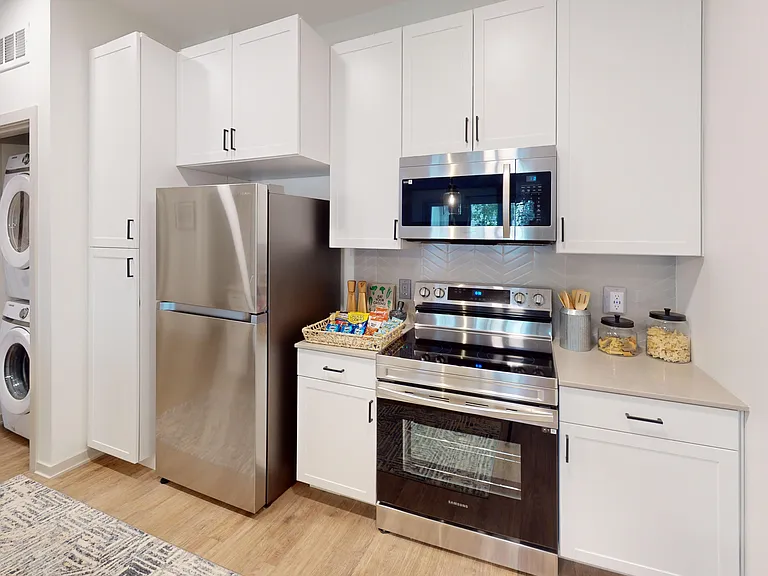 The Henry floor plan features stainless steel appliances, including a glasstop stove and built-in microwave range. A washer and dryer is also conveniently hidden for easy access. The Henry floor plan features stainless steel appliances, including a glasst