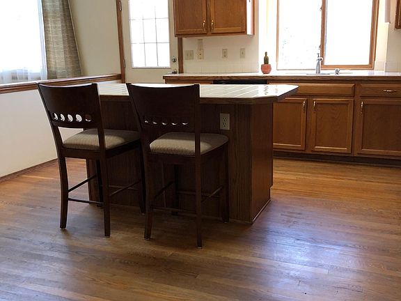 Kitchen island, backdoor, adjoining living room with fireplace