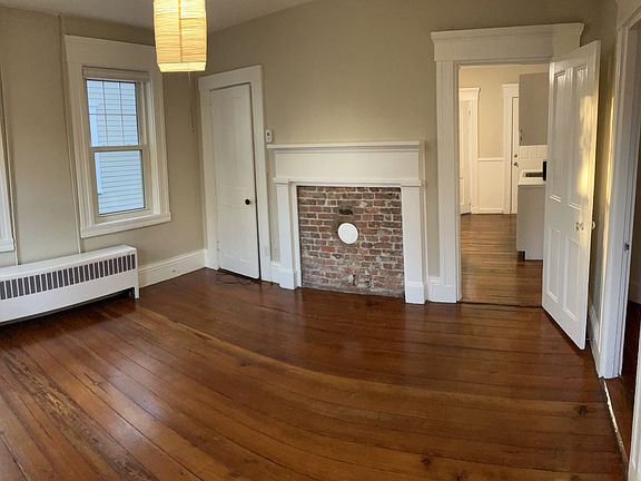 Living room features historic fireplace mantle, closet, and lots of light.
