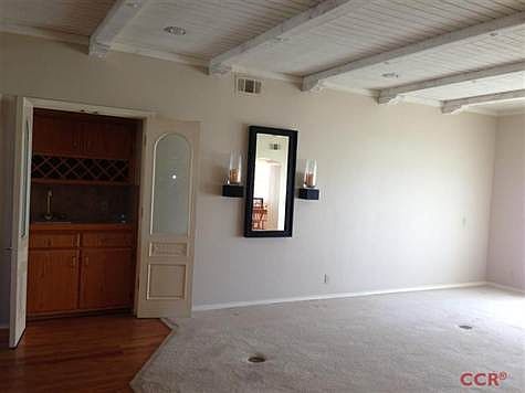 Spacious family room with wet bar, large fireplace, bookshelves, and french doors