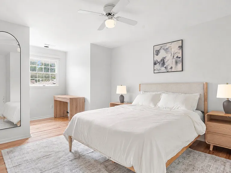 Inviting upper-level queen bedroom with clean linens, comfortable furnishings, and a dedicated writing desk.