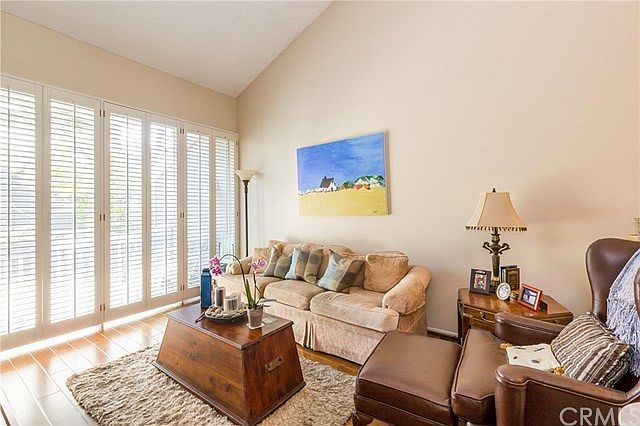 Beautiful Open Living Room With Soaring Vaulted Ceilings, Hardwood Floors and Plantation Style Shutt