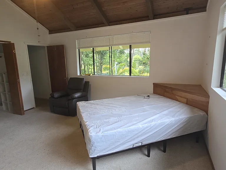 Partially furnished with a Queen sized bed and a recliner.