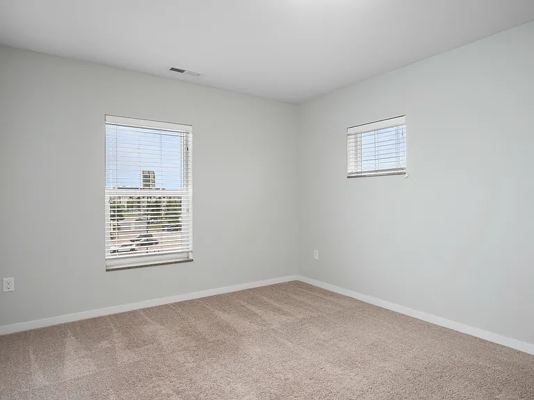 Bright and inviting corner room with plush carpeting and ample natural light from large windows. Bright and inviting corner room with plush carpeting and ample natural light from large windows.