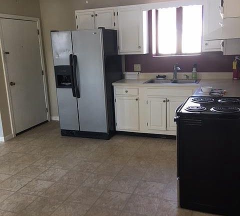 View of kitchen from private entrance. Stainless steel fridge was replace with a black one.
