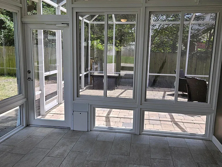 Sunroom exit to the screened room on the right. Small dog door accessible to the screen room.