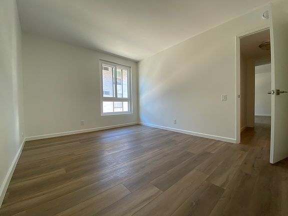 Second bedroom with mirrored closet doors. Dimensions 13 feet by 10.5 feet.