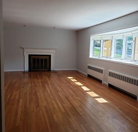 Living Room with woodburning fireplace and hardwood floors