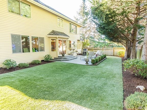 Spacious backyard with low maintenance synthetic turf, and fully fenced yard