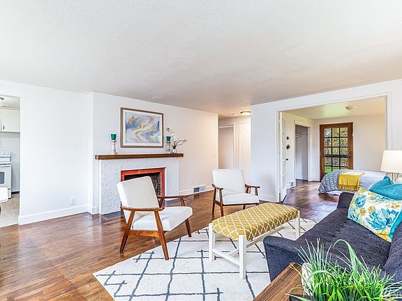 With warm hardwoods under foot, this spacious living room promises comfort and relaxation. Freshly painted throughout, the home sparkles. French doors swing open to the master bedroom and lovely garden oasis beyond.