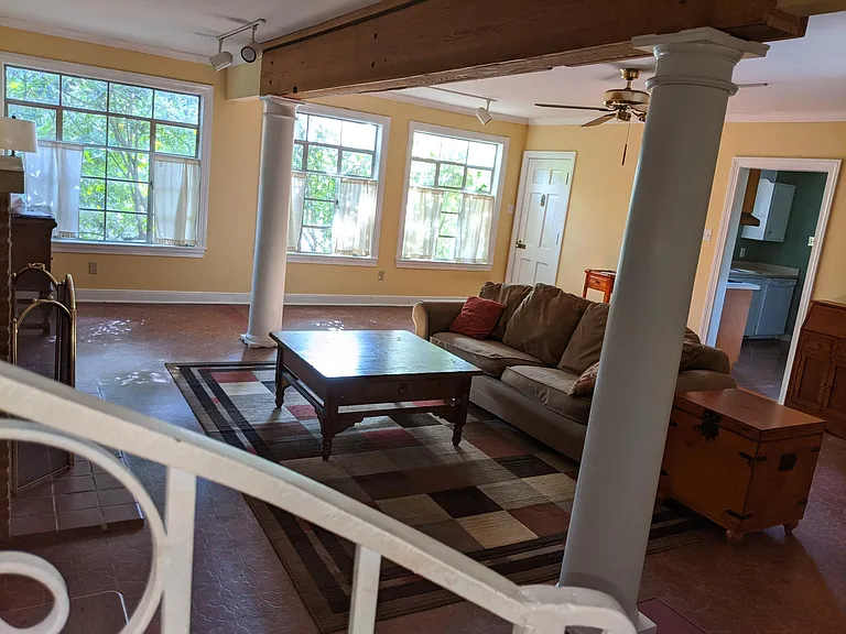Downstairs Great Room - 20ft x 28ft _ with Wood Burning Fireplace & White Wooden Columns.