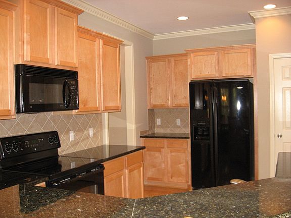 Kitchen features granite countertops, tile backsplash, 