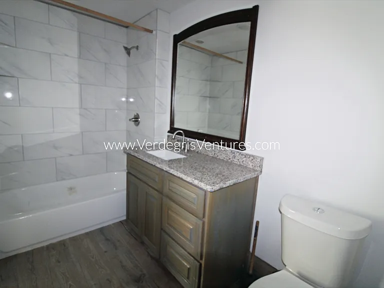 Bathroom 2 is accessed through the studio and is very spacious, featuring granite countertops, porcelain sinks, a bathtub, and additional room for storage