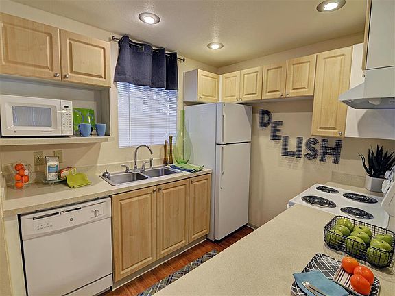 Natural wood cabinets and white appliances brighten your kitchen and are sure to inspire your inner chef