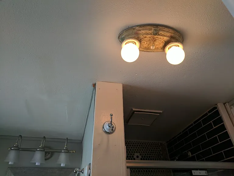 Restored antique light fixture in downstairs primary bathroom!