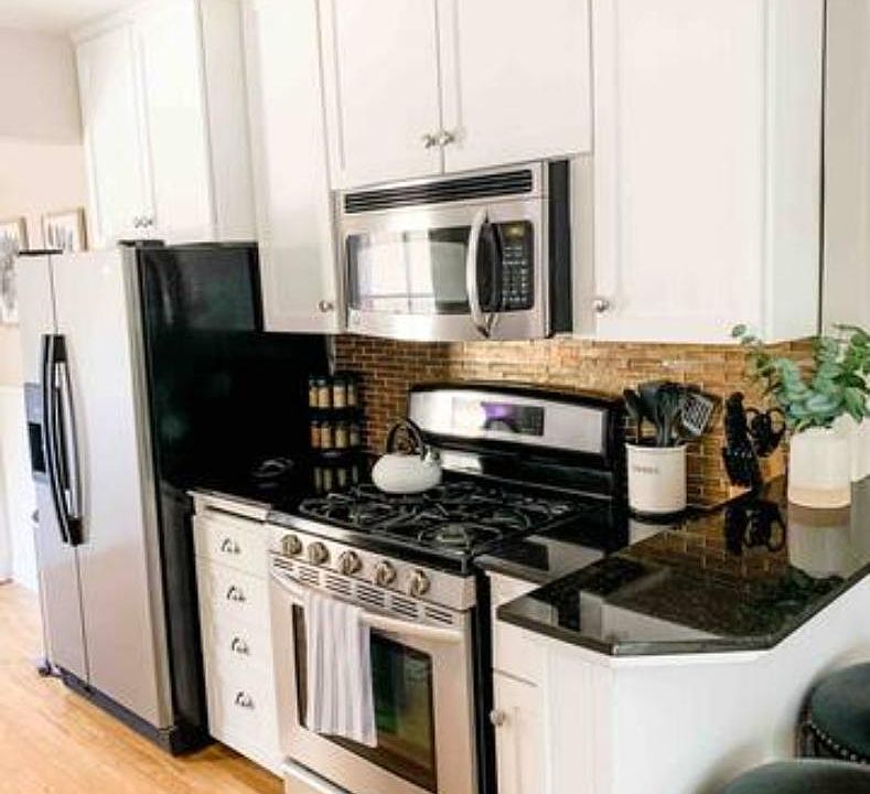 Four burner stove with above mounted microwave.