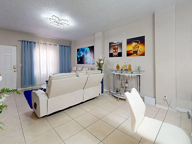 Bright and modern living room with elegant white sofas, stylish decor, and vibrant artwork, perfect for relaxation and entertaining.