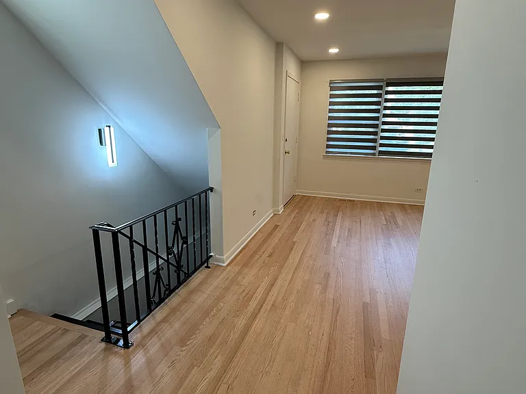 Front entrance, living room, and view of basement staircase leading to recreation room
