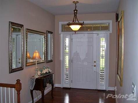 Wow! Truly magnificent entry is just as amazing on the inside as from the outside! Plantation shutters on the sidelites provide privacy! Natural light dances on the hardwood of the entry, flowing in from the transom & sitelites!