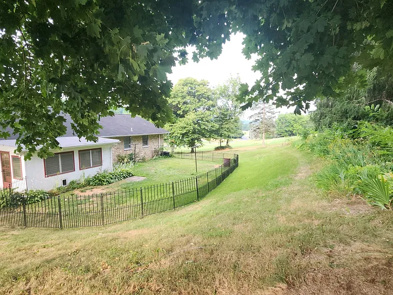 Fenced in yard with doggy door .