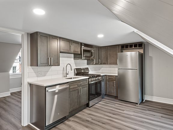 Kitchen with dishwasher, new cabinets, new appliances and quartz countertops.