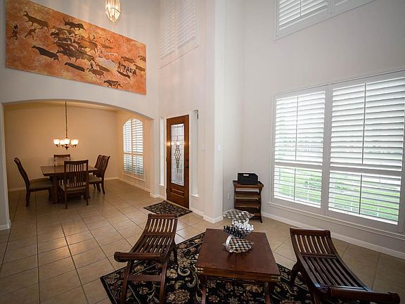 Across the entrance is a good size dining room with the continued custom shutters. Tile floors conti