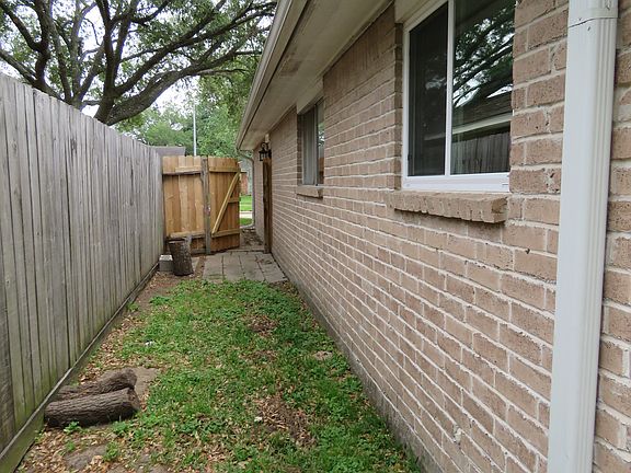Right side with gate entrance to backyard. Stone walk through.