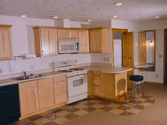 Kitchen with micro-range, laundry just beyond peninsula and fold down ironing board.