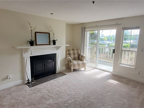 Living room with new carpet and wood burning fire.