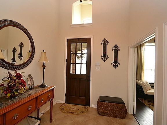 Elegant entry offering a beveled glass front door, tile flooring, raised ceilings and access to a ha