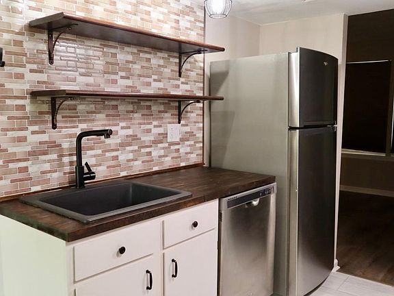 Dishwasher. Open Shelving. Faucet with attached hose. Towel hook.