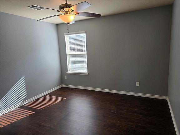 Unfurnished room featuring ceiling fan and dark hardwood / wood-style floors