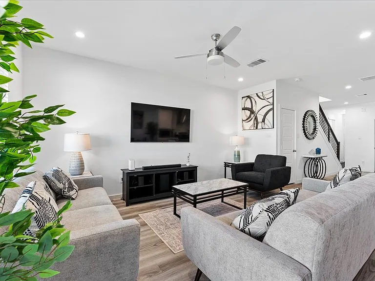 Sitting featuring Tv, Sound bar, comforable couch, end tables and fan.