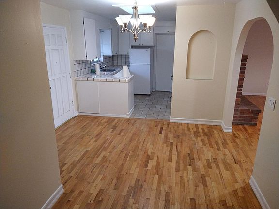 Dining area with main door entrance and kitchen in background