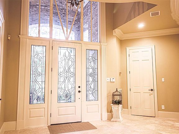 Beautiful entrance with gorgeous chandelier. 18' honed travertine all throughout except in master room. Gorgeous glass doors. Door to the right is garage and the extra size laundry room.