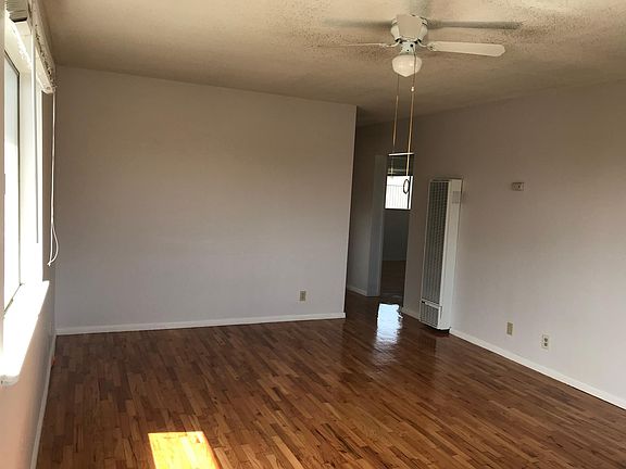Living room with ceiling fan and brand new wall heater. Sorr