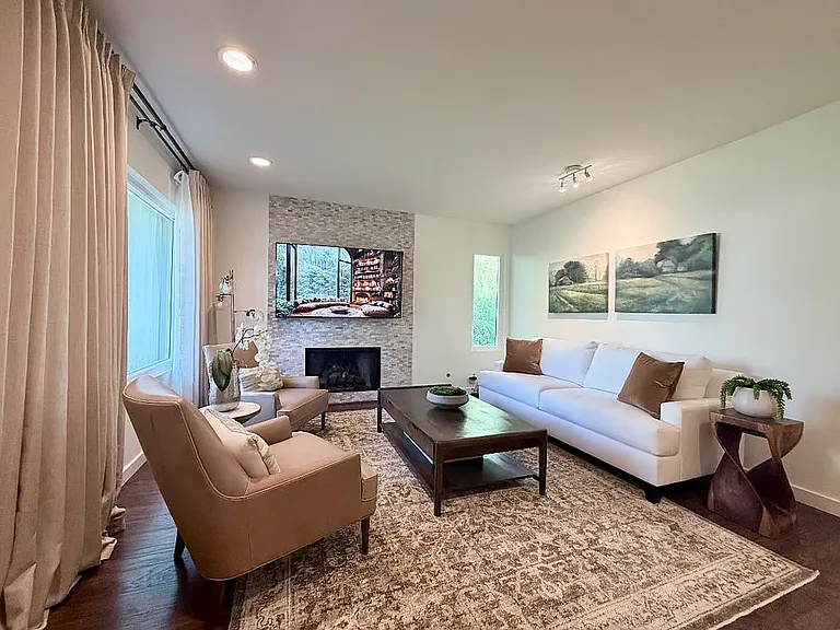 Bright, comfortable living room with cozy seating, fireplace, and smart TV, perfect for relaxing evenings.