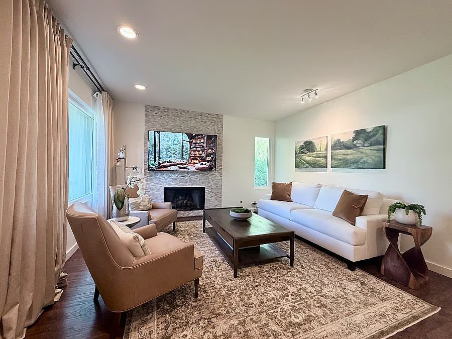 Bright, comfortable living room with cozy seating, fireplace, and smart TV, perfect for relaxing evenings.
