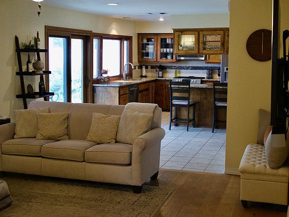 Open floor plan! View of family room into kitchen. Bar seating in kitchen with plenty of room for table seating in front of the sliding glass door that leads into private landscaped backyard.