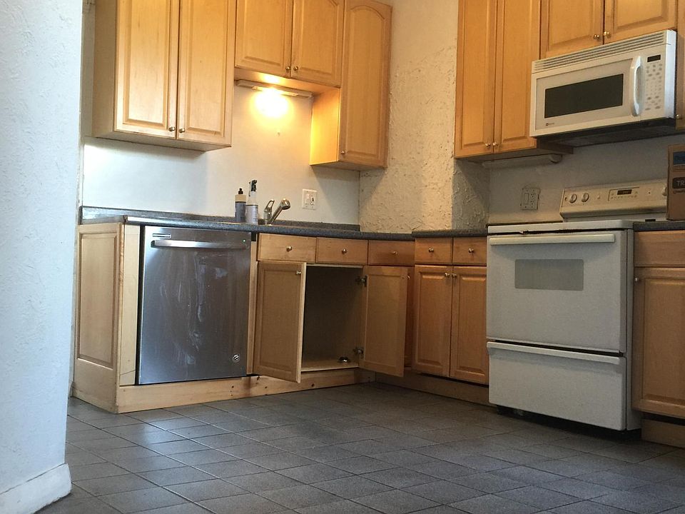 Kitchen with new dishwasher and microwave.