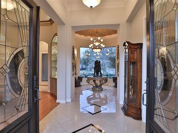 LAKE VIEWS FROM ENTRY - Open the elegant double front doors to this beautiful entry with rotunda and circular butted glass windows with gorgeous views.
