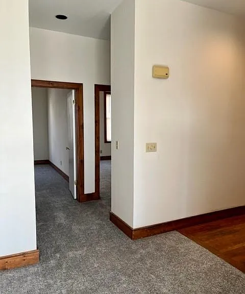Hall leading to bedrooms and bathrooms. Note, carpet replaced with wood laminate and trim painted white.