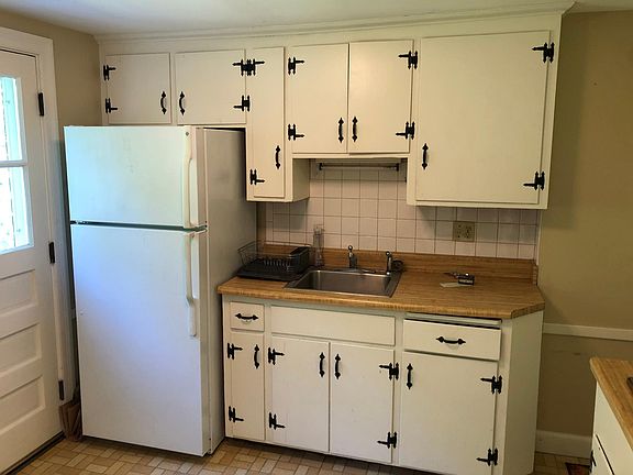 kitchen with refrigerator, gas stove/oven and steps down to
