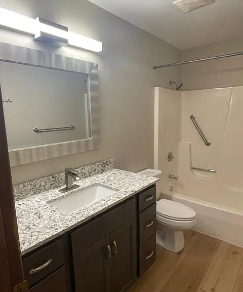 full bathroom with large mirror and shower/tub