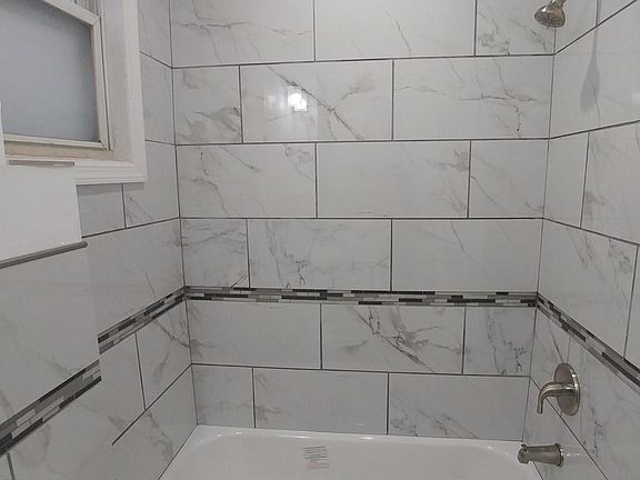 Completely tiled full bath with new tub, high powered toilet