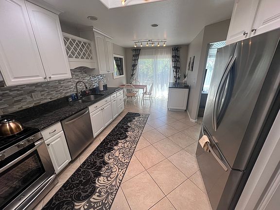 Large fully stocked galley kitchen with dining nook with separate entrance to back patio.