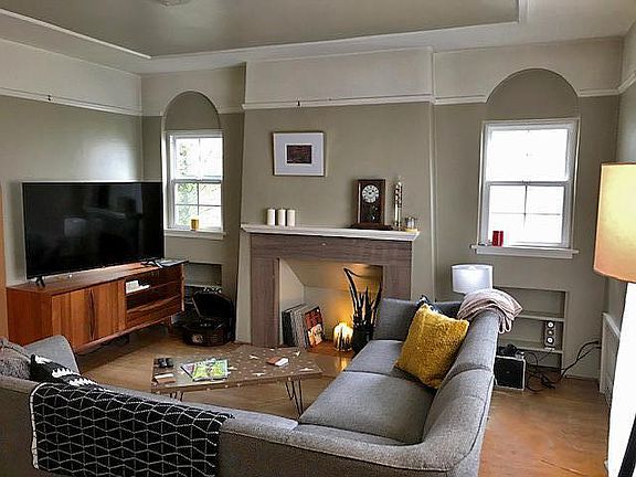 High ceilings, arched windows and bookshelf built-ins. Decorative fireplace.