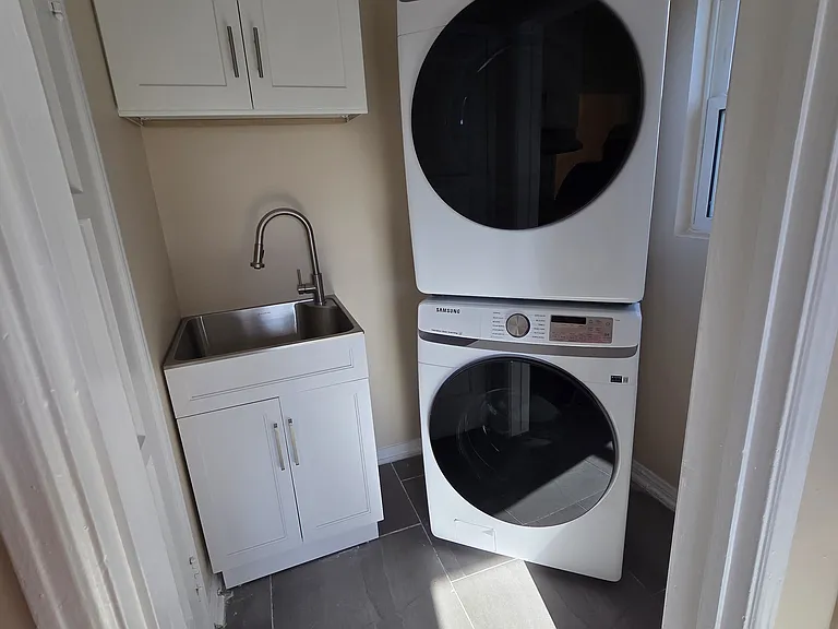Laundry room with brand new washer, dryer, cabinet, and sink