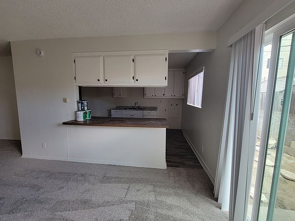 View into kitchen from living room; private backyard.