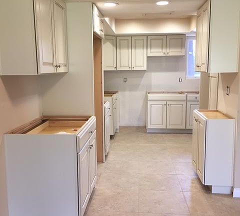 New cabinets waiting for granite counter tops with tile floors.